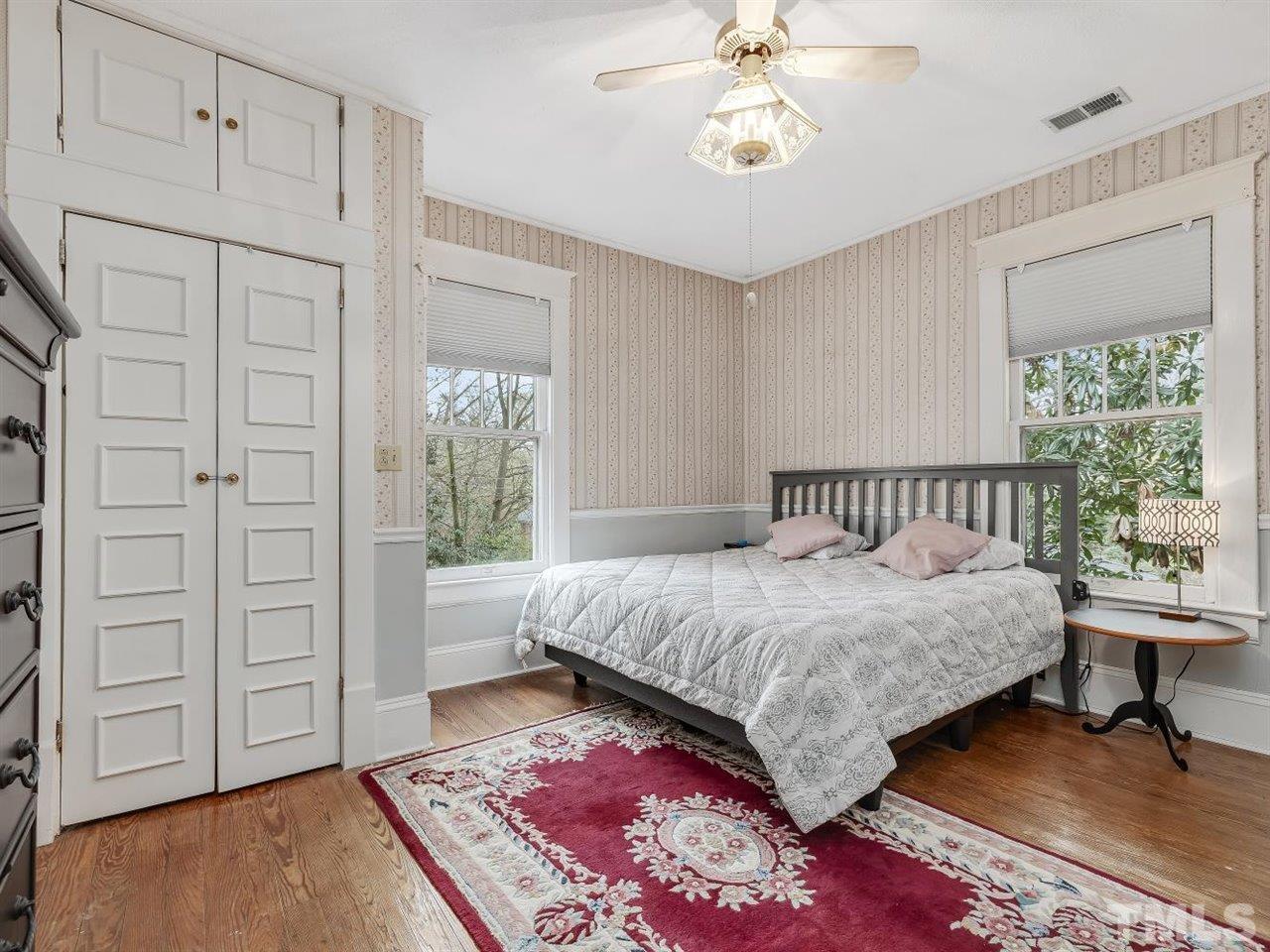 216 Hillcrest Road Raleigh, NC 27605 - Photo 27 of 49 a bedroom with a large bed and a chandelier
