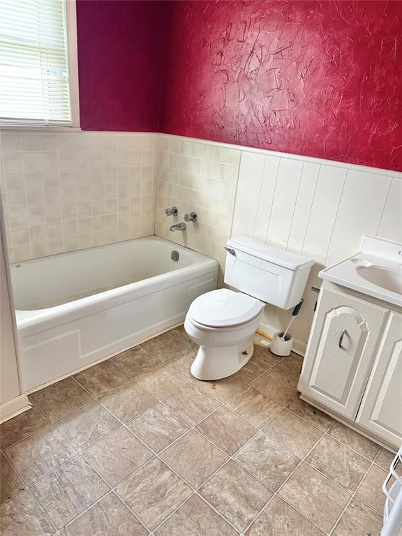 705 Loop Road Quanah, TX 79252 - Photo 8 of 14 a bathroom with a toilet a sink and bathtub