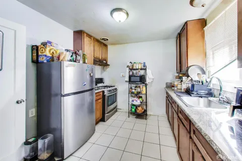 a kitchen with granite countertop a refrigerator and a sink