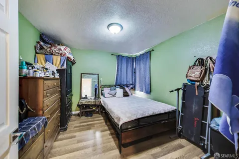 a bedroom with a bed and a flat tv screen on the dresser