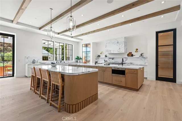 a kitchen with kitchen island granite countertop a sink and a wooden floors