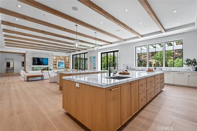 a large kitchen with kitchen island a large counter space a sink appliances and a large window