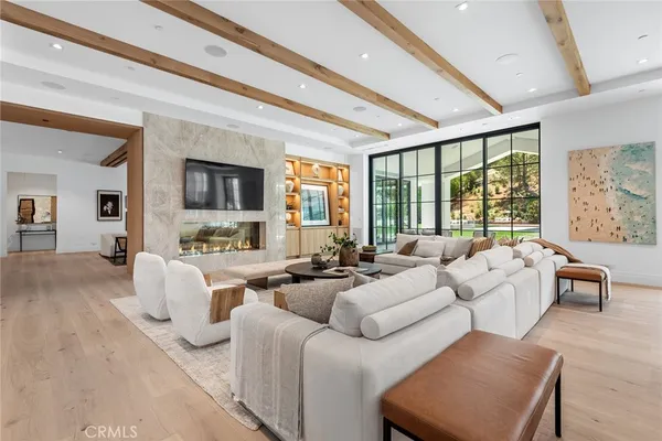 a living room with furniture large windows and flat screen tv