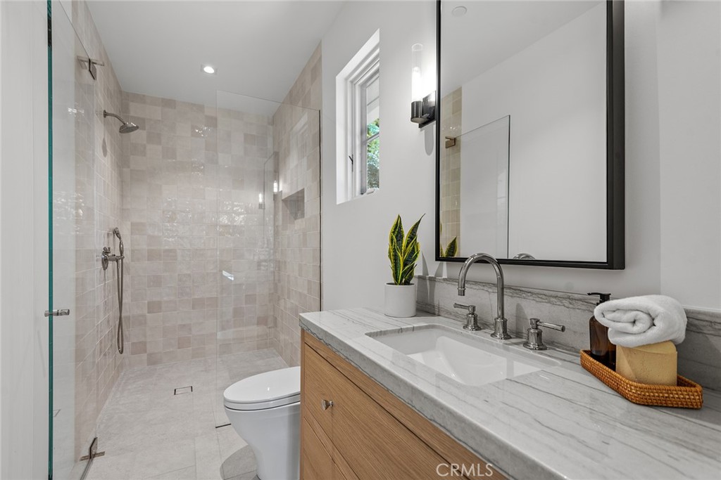 24044 Long Valley Road Hidden Hills, CA 91302 - Photo 55 of 57 a bathroom with a granite countertop sink toilet and shower