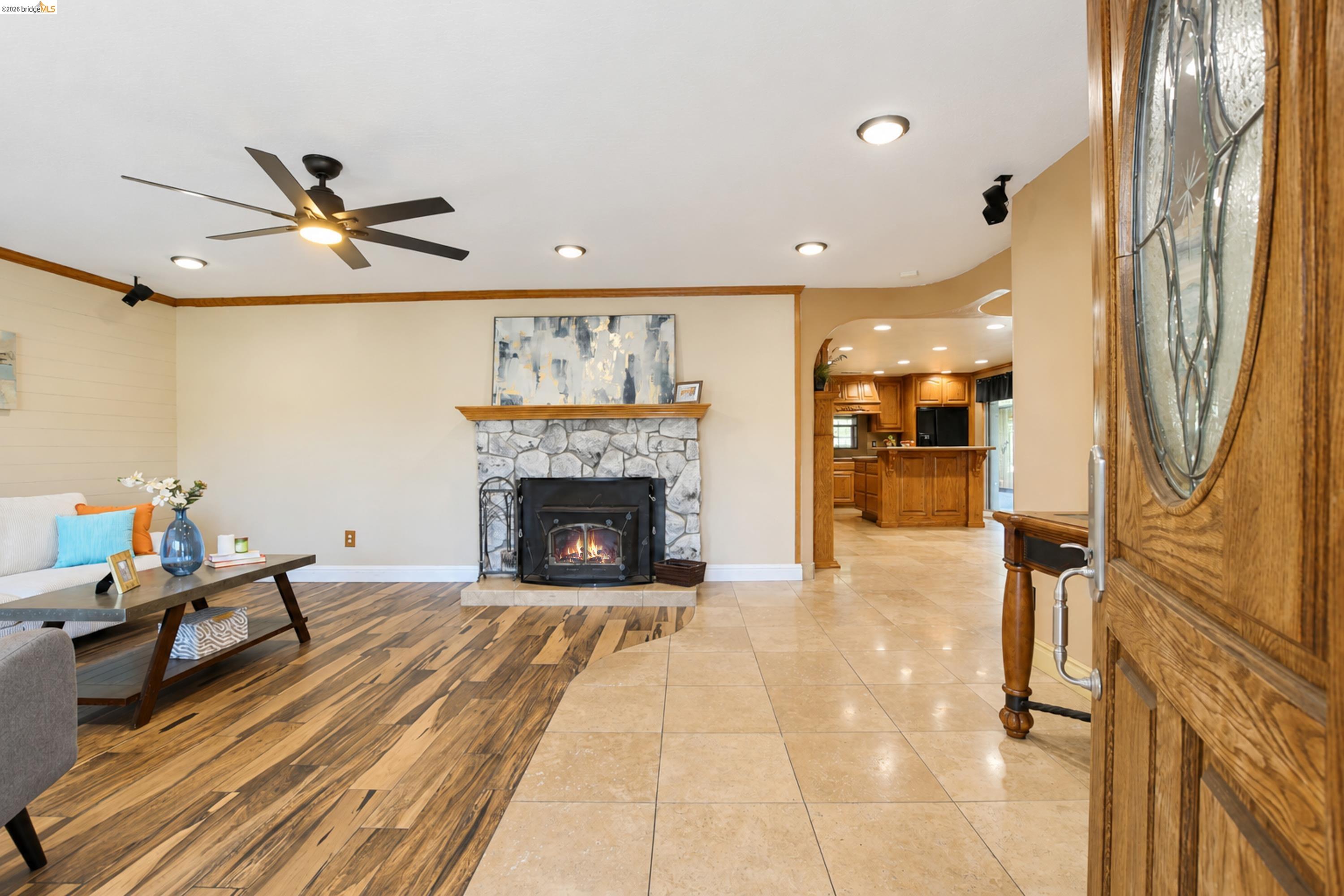 340 West Bolton Road Oakley, CA 94561 - Photo 12 of 87 Stone-front fireplace with a wood mantel, overhead lighting, wood-finish flooring, and a decorative front entry door with leaded glass