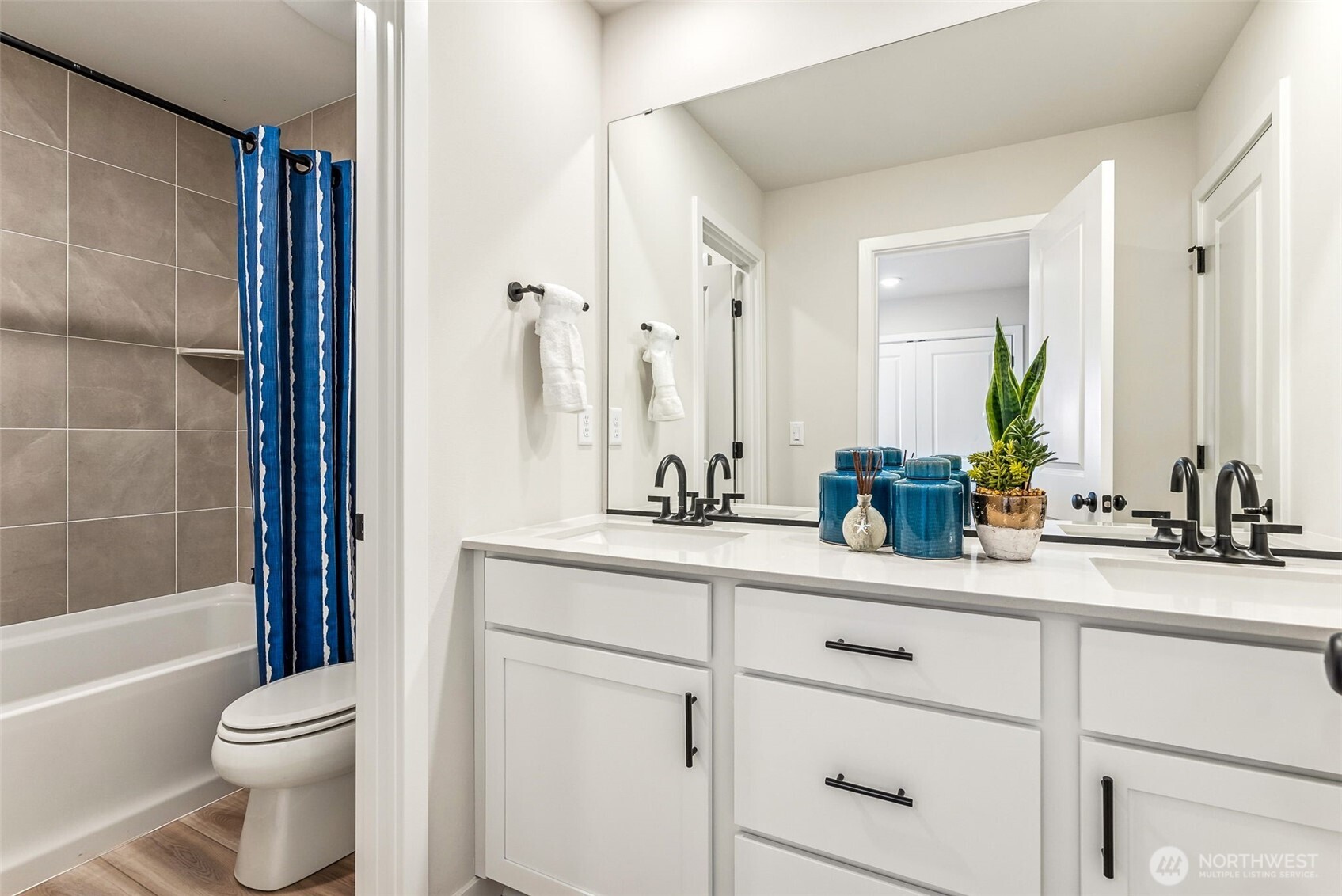 17535 Northeast Midnight Sun Loop Poulsbo, WA 98370 - Photo 19 of 38 a bathroom with a sink a toilet a mirror and shower