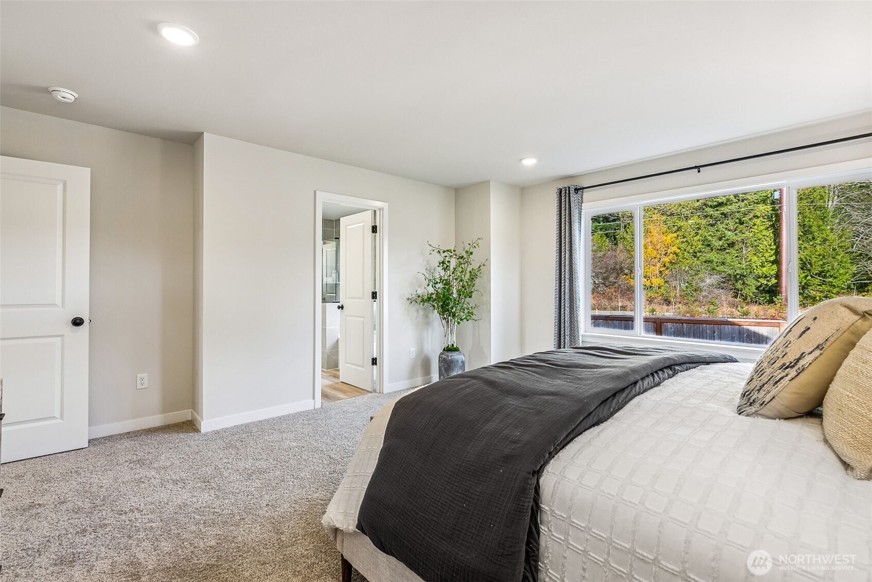 17535 Northeast Midnight Sun Loop Poulsbo, WA 98370 - Photo 22 of 38 a spacious bedroom with a bed and a large window