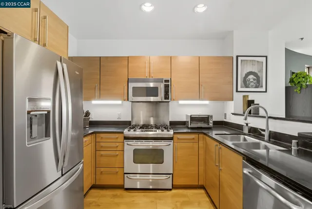a kitchen with a sink a refrigerator and a stove top oven