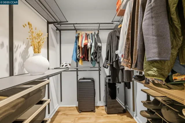 a view of walk in closet with clothes and shoes