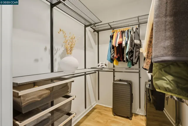 a view of walk in closet with clothes and shoes