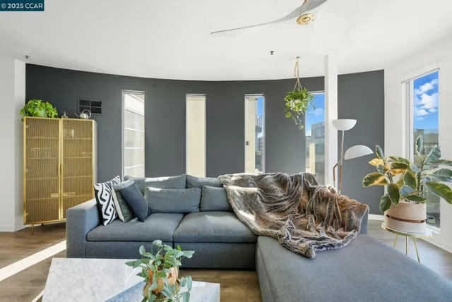 a living room with furniture flowerpot and wooden floor