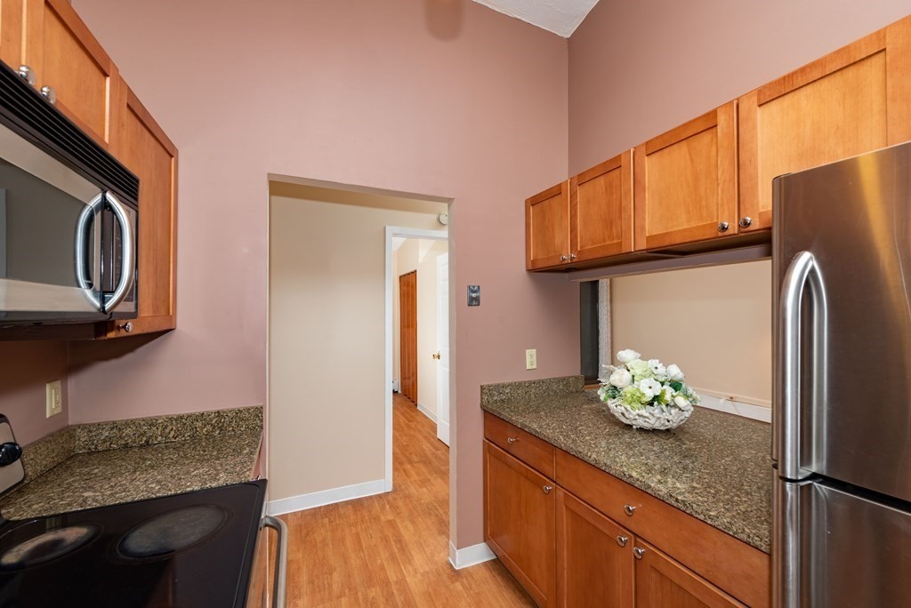 4 Raintree Circle, Unit 4D Brockton, MA 02302 - Photo 18 of 24 a kitchen with stainless steel appliances granite countertop a refrigerator