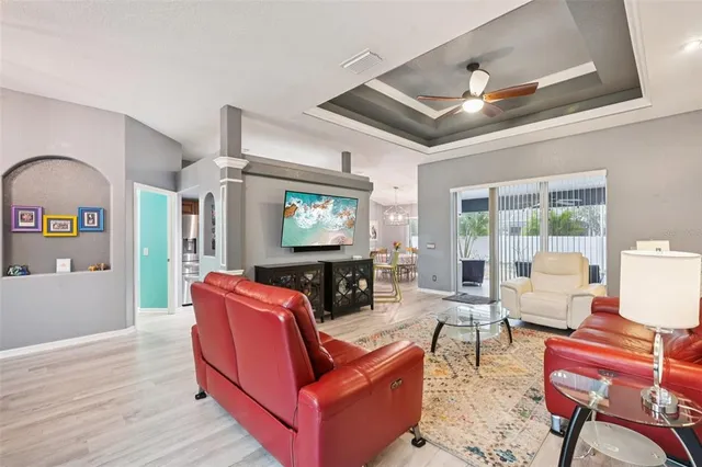 a living room with furniture a flat screen tv and wooden floor