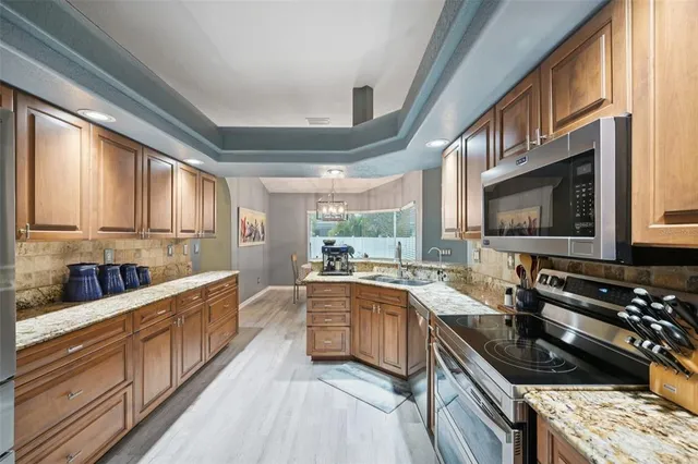 a kitchen with lots of counter top space a sink and stainless steel appliances