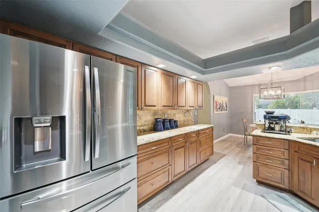a kitchen with stainless steel appliances granite countertop a refrigerator a stove and a sink