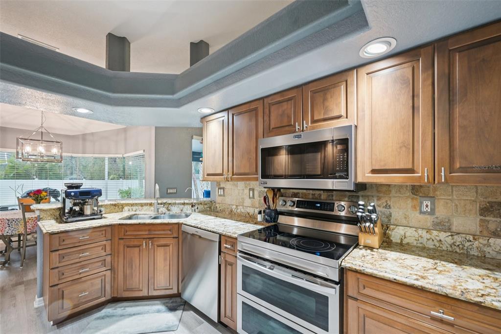 4337 Langsom Lane North Port, FL 34286 - Photo 16 of 42 a kitchen with stainless steel appliances a stove sink microwave and cabinets