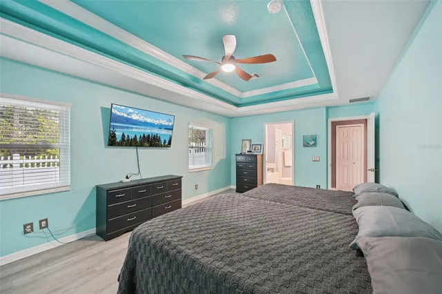 a bedroom with a bed and a flat tv screen on dresser