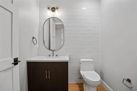 a bathroom with a toilet sink and mirror