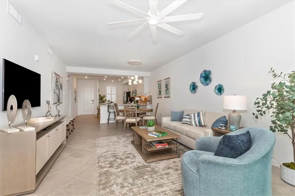 a living room with furniture a chandelier and a dining table