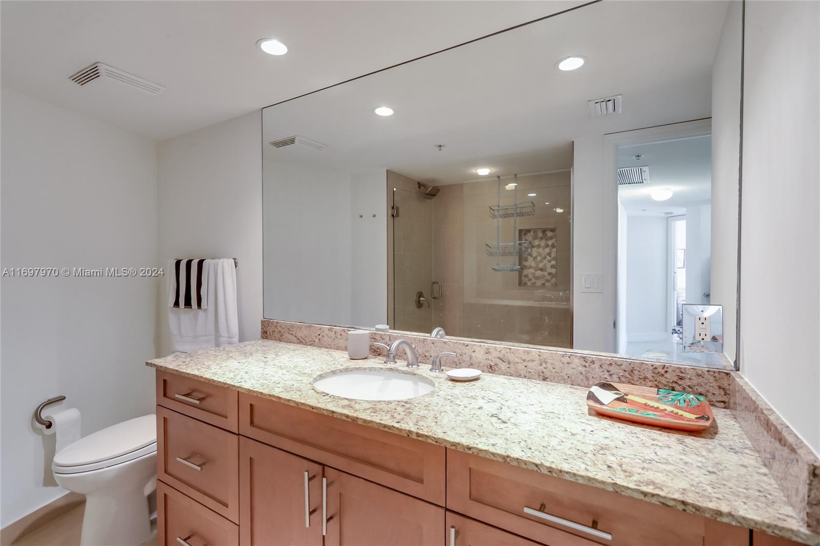 3000 North Ocean Drive, Unit 10B Riviera Beach, FL 33404 - Photo 6 of 31 a bathroom with a granite countertop sink a toilet and a mirror
