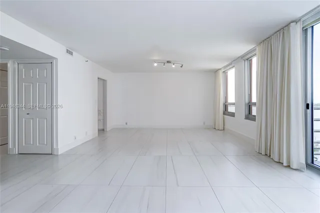 a view of an empty room with a kitchen