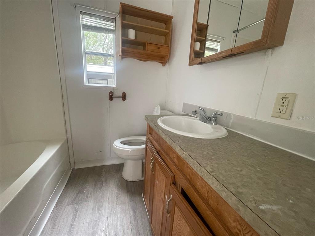 3000 Clarcona Road, Unit 830 Apopka, FL 32703 - Photo 15 of 28 a bathroom with a granite countertop sink a toilet and bathtub