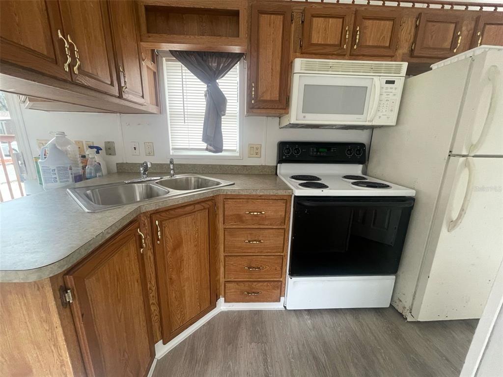 3000 Clarcona Road, Unit 830 Apopka, FL 32703 - Photo 10 of 28 a kitchen with stainless steel appliances a stove a sink and a microwave