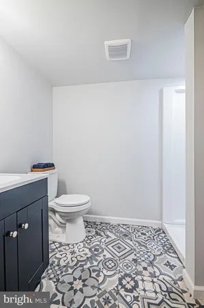 a white toilet sitting next to a shower