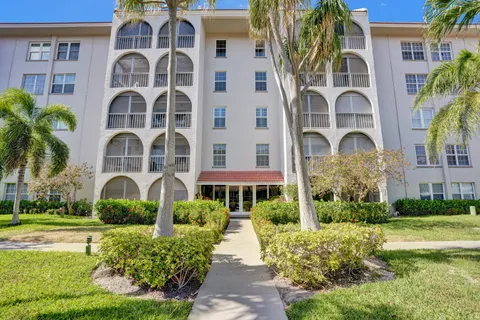 a front view of a multi story building with yard