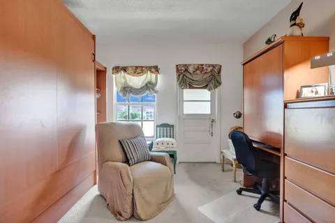a bedroom with a bed and a couch next to a window