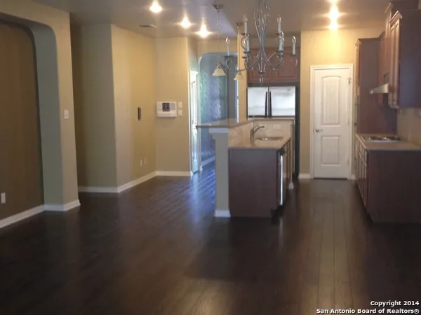 a view of a hallway with wooden floor windows and a kitchen