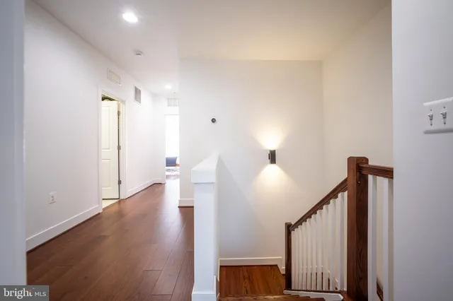 a living room with furniture and kitchen view with wooden floor