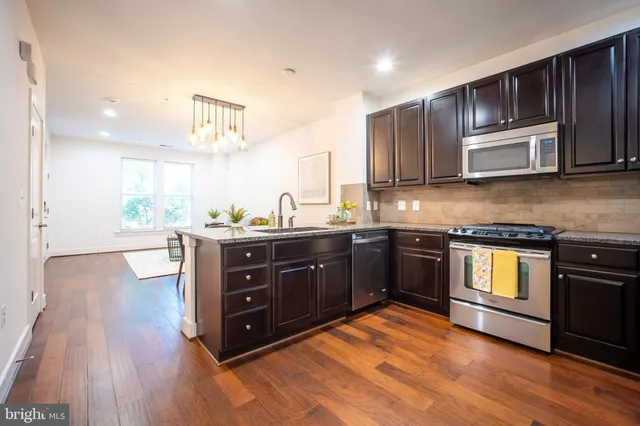 a kitchen with stainless steel appliances granite countertop a sink and cabinets