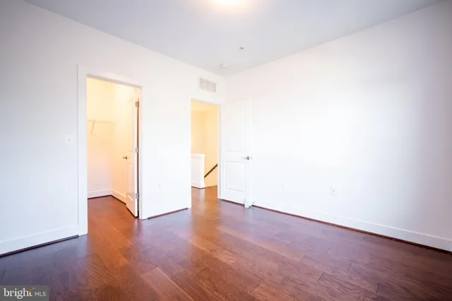 a view of an empty room with wooden floor