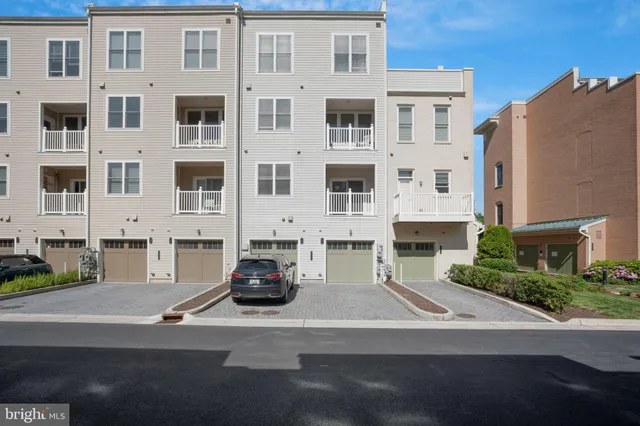 a front view of residential houses and trees