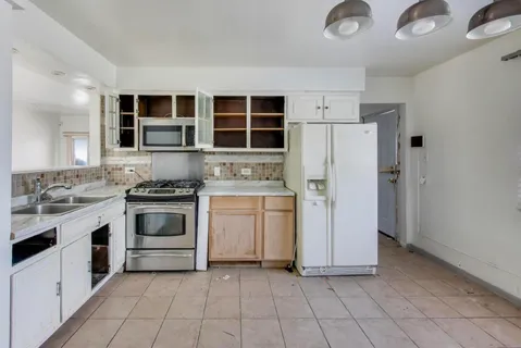 a view of a kitchen with a sink dishwasher and a refrigerator