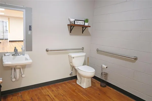 a bathroom with a toilet a sink and mirror