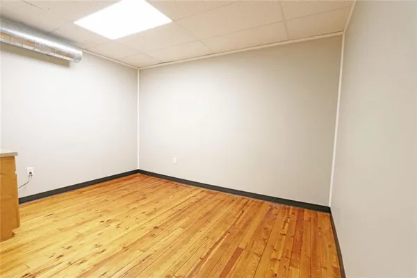 a view of a room with wooden floor and white walls