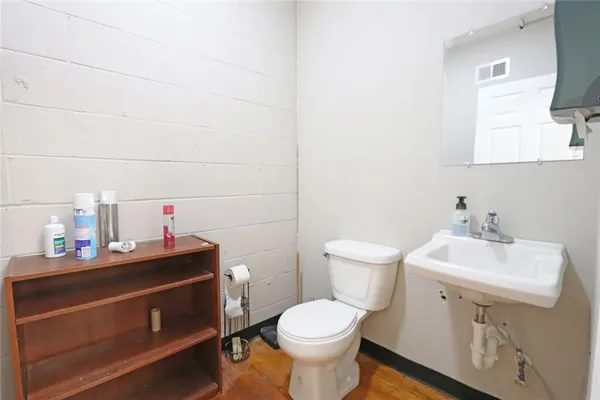 a bathroom with a sink toilet and a mirror