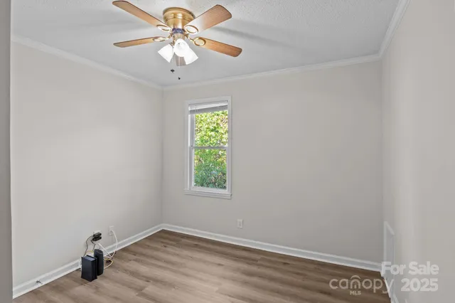 an empty room with a window and a fan