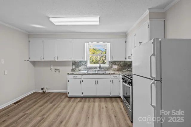 a kitchen with a refrigerator and a stove top oven