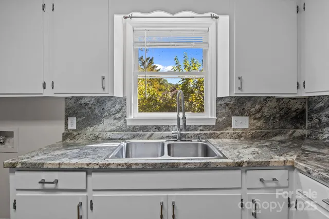 a kitchen with granite countertop a sink and a window