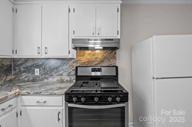 a stove top oven sitting inside of a kitchen