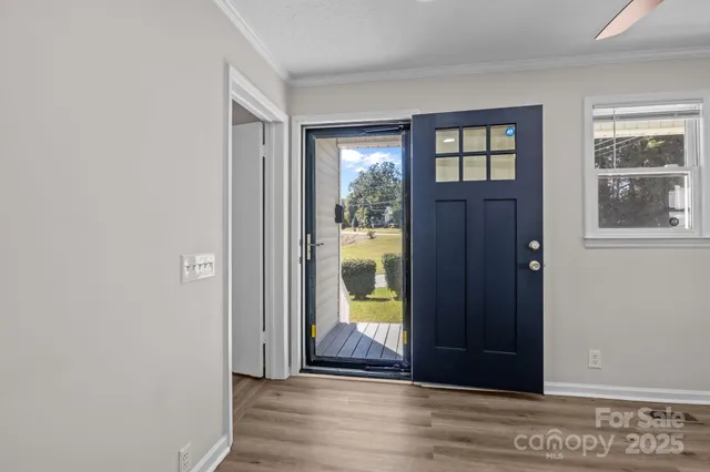 a view of a hallway with wooden floor and windows