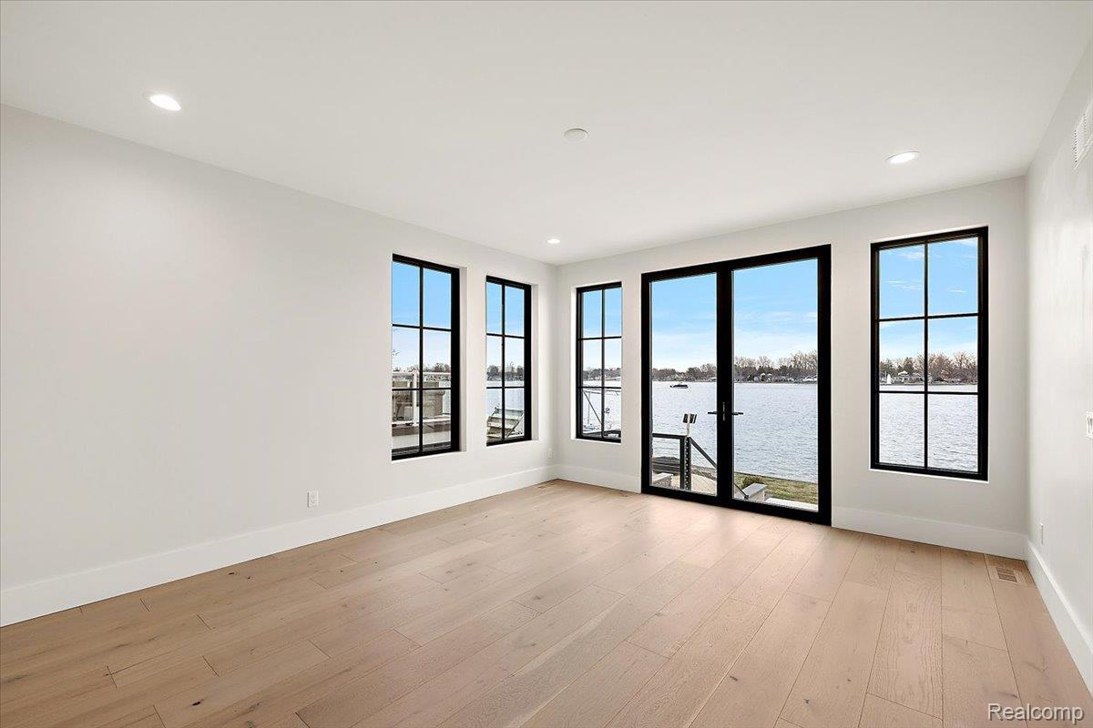 13459 Haddon Street Fenton, MI 48430 - Photo 16 of 84 Empty room featuring a water view, light wood-type flooring, and recessed lighting