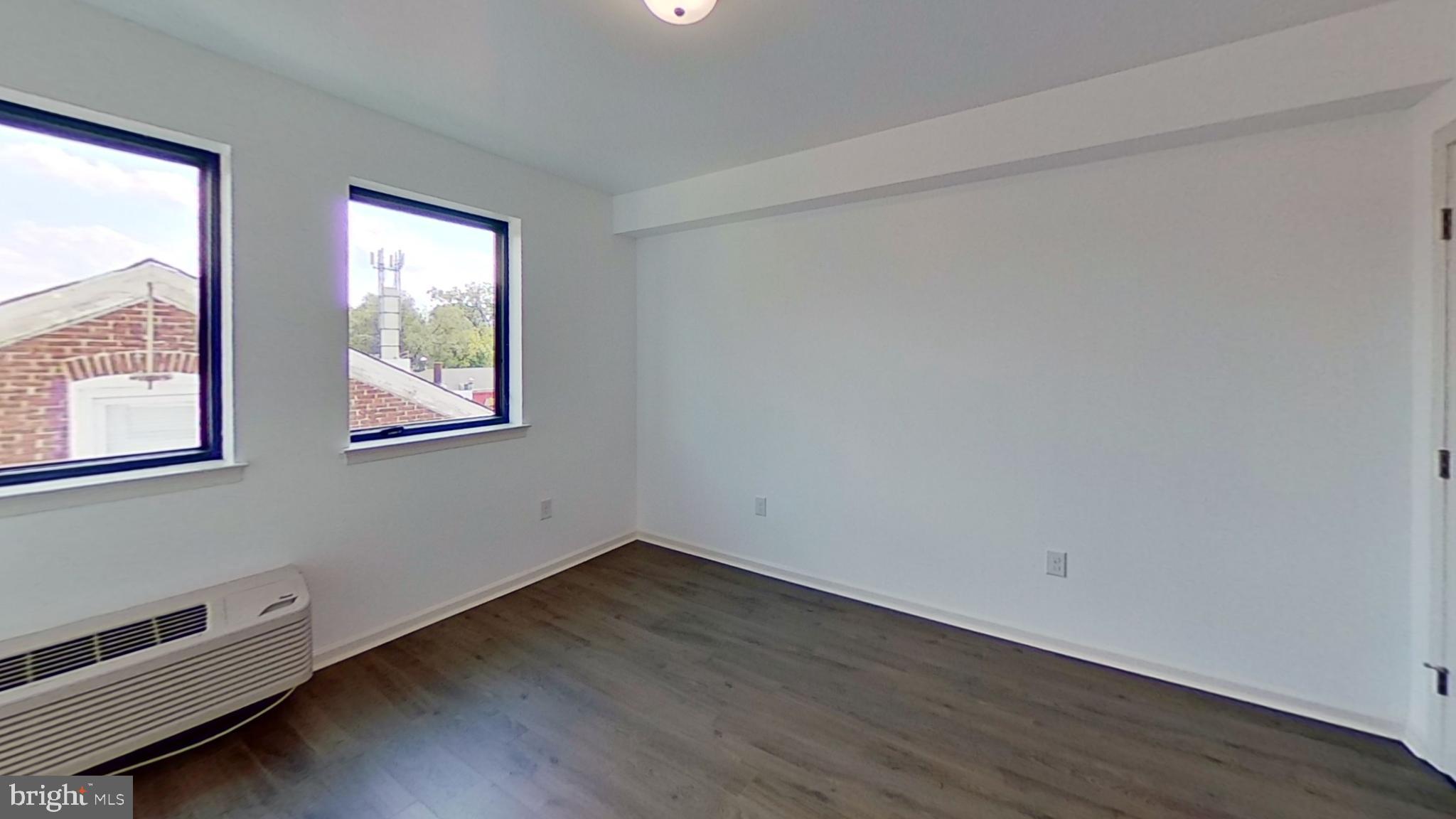6778 Ridge Avenue, Unit 205 Philadelphia, PA 19128 - Photo 2 of 7 an empty room with wooden floor and windows