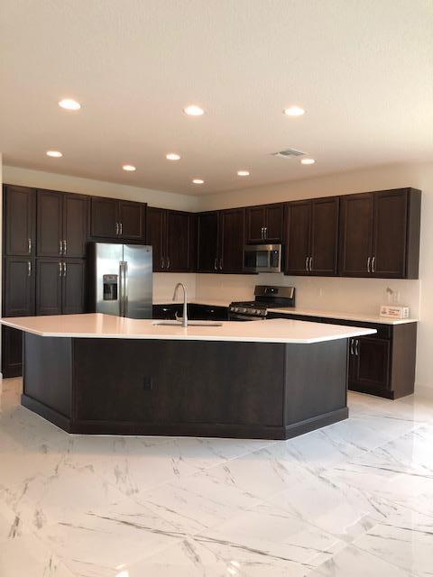 11670 Southwest Sailfish Isles Way Port St. Lucie, FL 34987 - Photo 7 of 25 a view of kitchen with stainless steel appliances kitchen island sink and stove