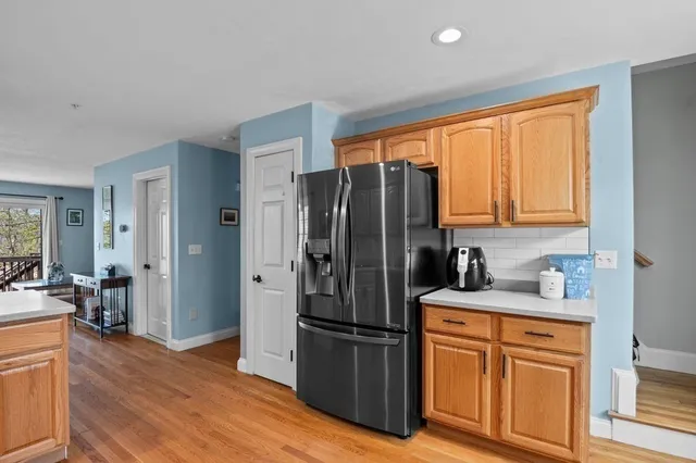 a kitchen with stainless steel appliances a refrigerator sink and wooden floor
