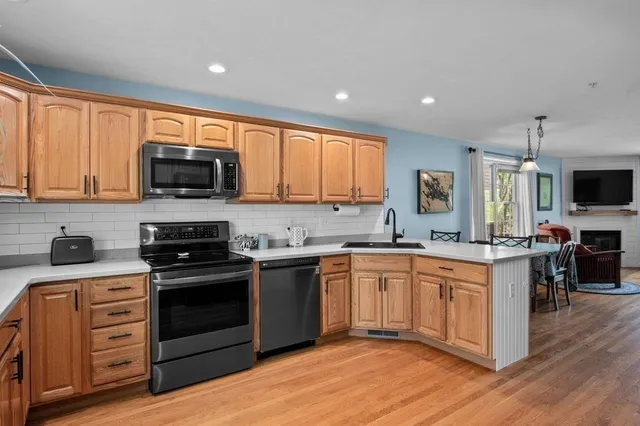 a kitchen with stainless steel appliances granite countertop a stove top oven a sink dishwasher a refrigerator and a microwave