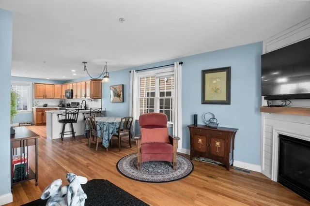 a living room with furniture a flat screen tv and kitchen view